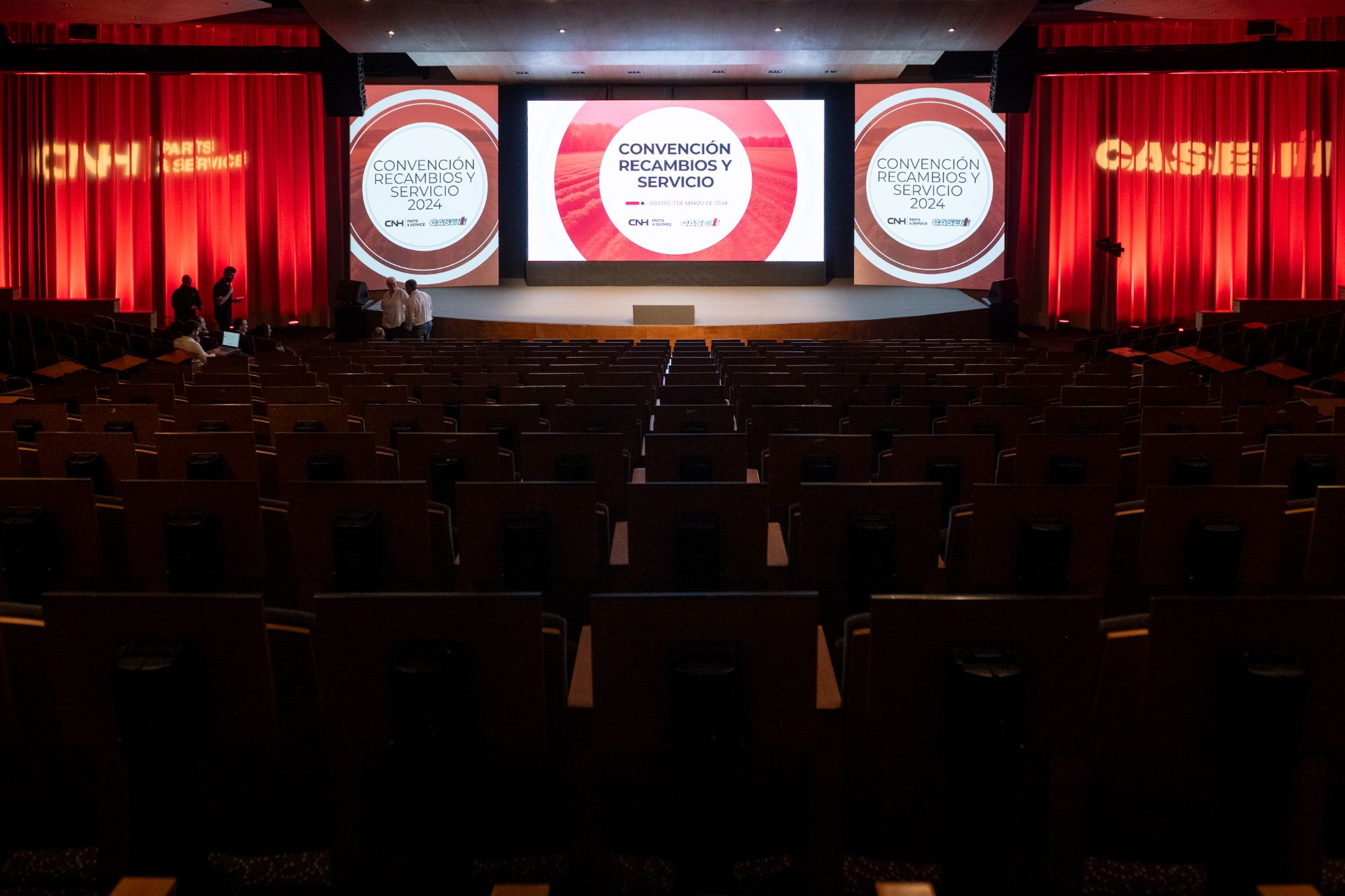 Auditorio con tres pantallas preparado para una convención