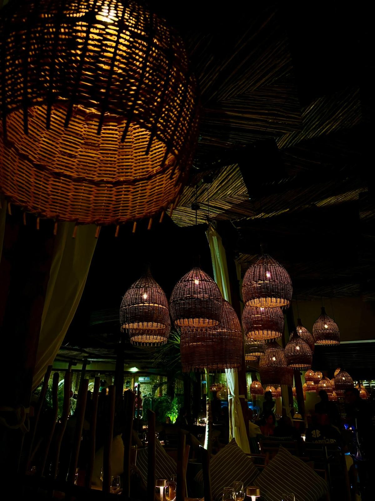 Restaurante iluminado con lámparas de fibra natural preparado para una cena de grupo